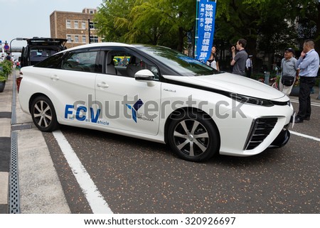 YOKOHAMA, JAPAN - SEPTEMBER 22, 2015: Fuel cell vehicle Mirai of Toyota is displayed on the street in an event called Car-free Day. Some of people who gather in the event are looking at the car.
