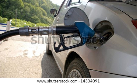 On leading-in grey car is fuelled by fuel. The Gun is inserted in tank..