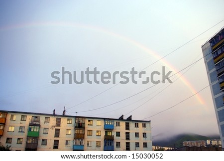 The Rainbow on city at evening , before sundown.The Rainbow and house, which is painted in crimson light calling at sun, twilight