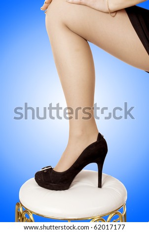 Nice woman\'s leg in classical black shoe against  colorful background.