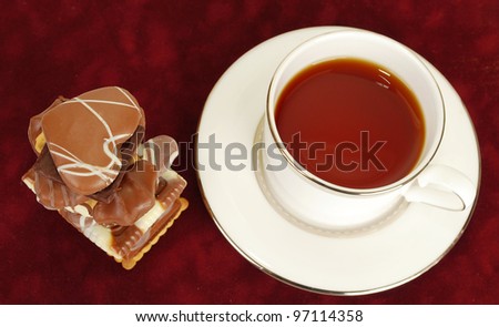 Chocolate assort  set cookies  with cup of tee  on red  background.