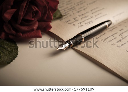 fountain pen on text sheet paper with rose close-up