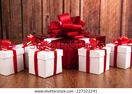 one red gift box white gift boxes on a wood background