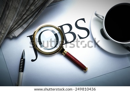 title jobs with loupe, pen, newspapers, cup of coffee