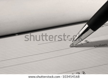 Close up of pen filling out a personal bank check with copy space.