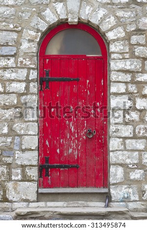Old vintage rustic exterior red door detail on old brick building.