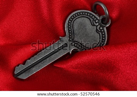 Old vintage key in red satin cloth background