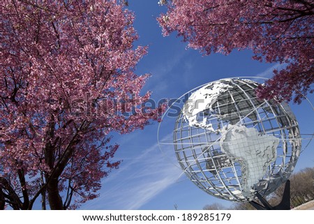 NY - APRIL 20, 2014: The Unisphere with cherry blossom trees in Flushing Meadows Corona Park at New York City.