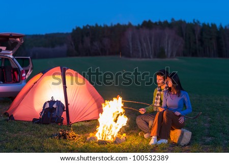 Tent camping car couple romantic sitting by bonfire night countryside