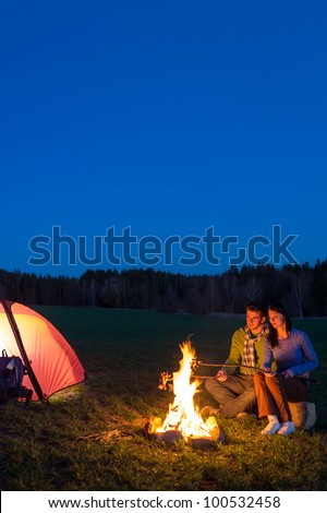 Camping night couple cook by campfire backpack in romantic countryside