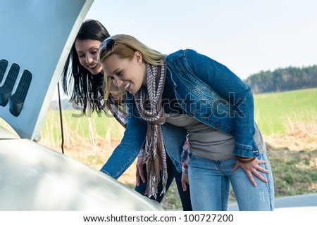 Car breakdown women looking under hood try to repair motor