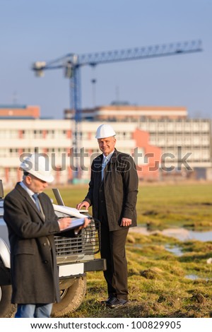 Male architect developers on construction site making notes building project