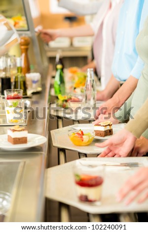 Desserts at cafeteria people with serving tray self service canteen