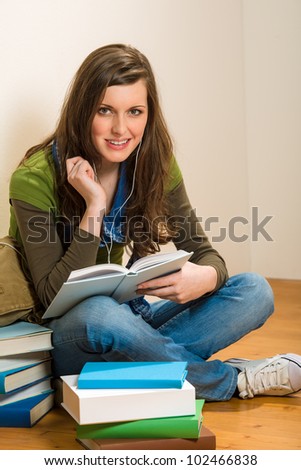 Portrait of student teenager woman with book listen music