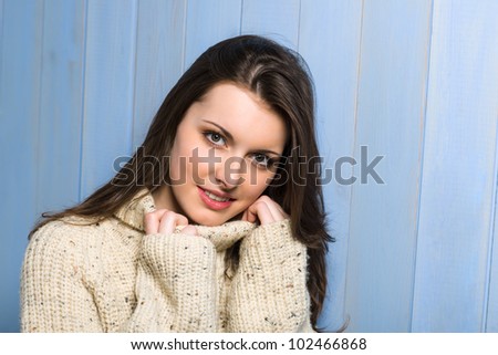 Beautiful smiling winter woman wearing beige sweater portrait