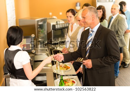 Cafeteria man pay by credit card cashier food on serving tray
