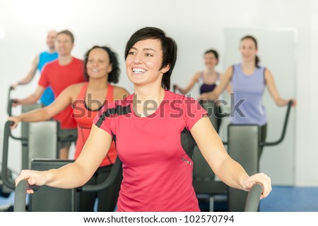 Smiling woman at fitness class gym workout on treadmill