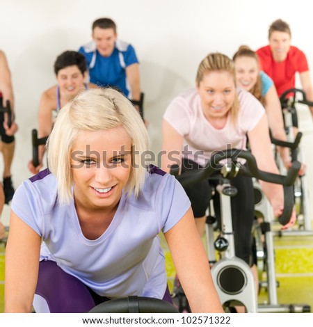 Fitness young woman on gym bike indoor cardio exercise