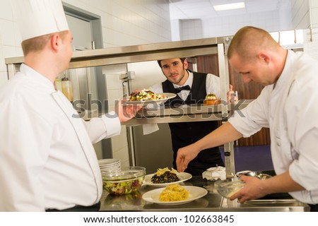 Professional kitchen cook prepare food service give meals to waiter
