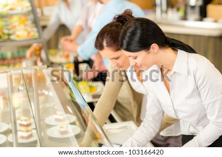 Cafeteria lunch two office colleagues woman choose food dessert self-service