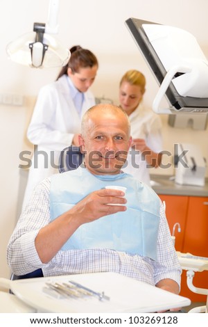 Mature man being treated at dental surgery smiling