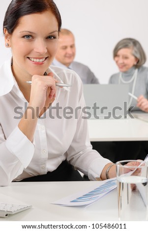 Young executive woman review charts during meeting with team colleagues