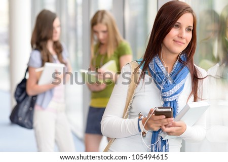 Female student listening mp3 player in high school hall