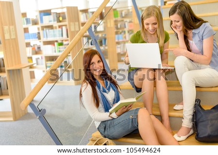 Three teenage female studying together on high school library stairs