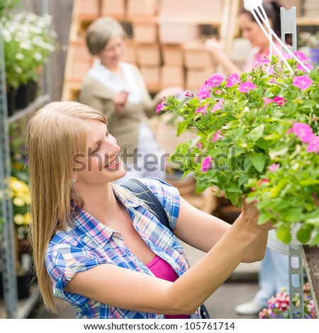 Young woman shopping flowers at market garden center