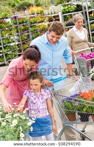 Young family choosing flowers at garden centre retail store
