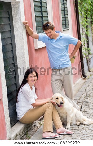 Happy couple resting with dog on street pet smiling love
