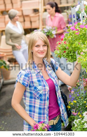 Young woman shopping flowers at market garden centre
