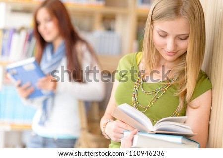 Happy female blonde student at library read books high school
