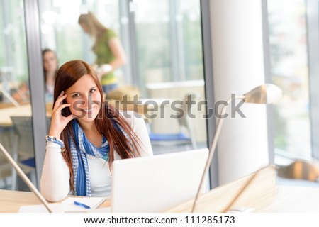 Female student smiling with laptop at high school study room