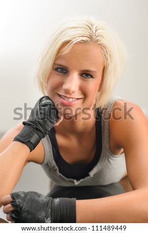 Female kick boxer laying down on black floor close-up portrait