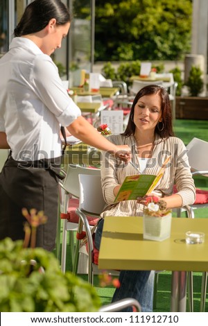 Waitress point menu woman in cafe bar terrace order food
