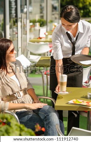Waitress serve woman latte at cafe bar terrace sunny day