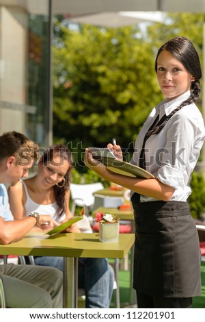 Waitress waiting for clients to decide cafe order restaurant terrace