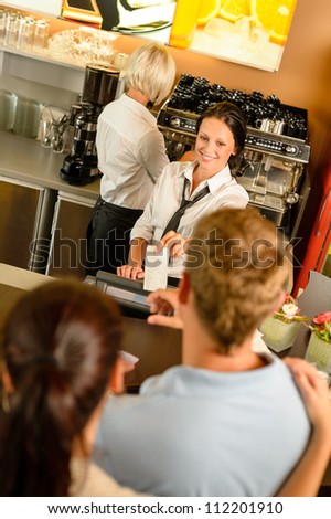 Cafe employee woman giving man bill receipt woman customer bar