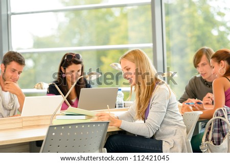 High-school students studying in library together academic teenagers study