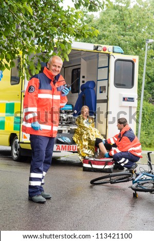 Emergency radio calling paramedics helping woman bike accident ambulance