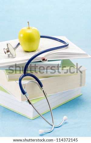 Medical books, apple and stethoscope healthy lifestyle medical research