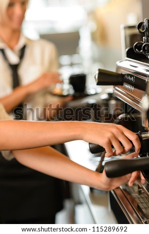 Close up hands waitress make coffee at work espresso machine