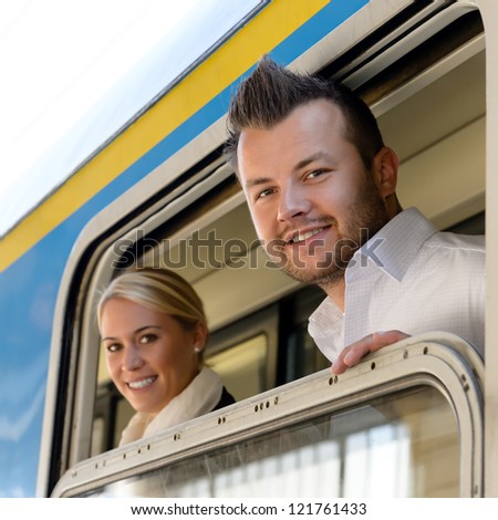 Man and woman in train looking window smiling commuters friends