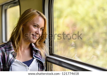 Happy woman looking out train window pensive vacation traveling tourist