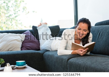 Young Woman Lying Reading Book Couch Sofa Living Room
