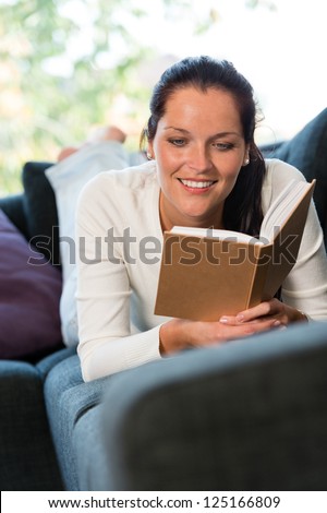 Female student studying couch home bookworm woman living room