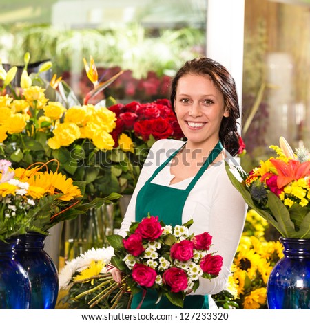 Cheerful female florist bouquet roses flower shop posing owner