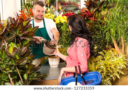 Man selling pot woman customer flower shop gardening plant