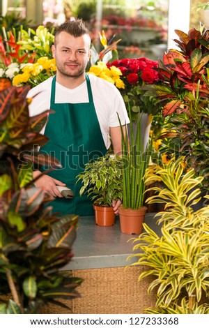 Young man scanning bar-code flower shop gardening florist